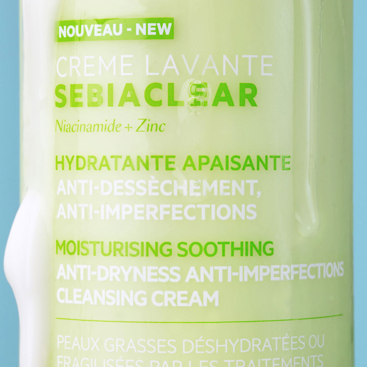 Una parte de la botella del SEBIACLEAR Creme Levante escurriendo una parte del productom en la botella en un fondo azul
