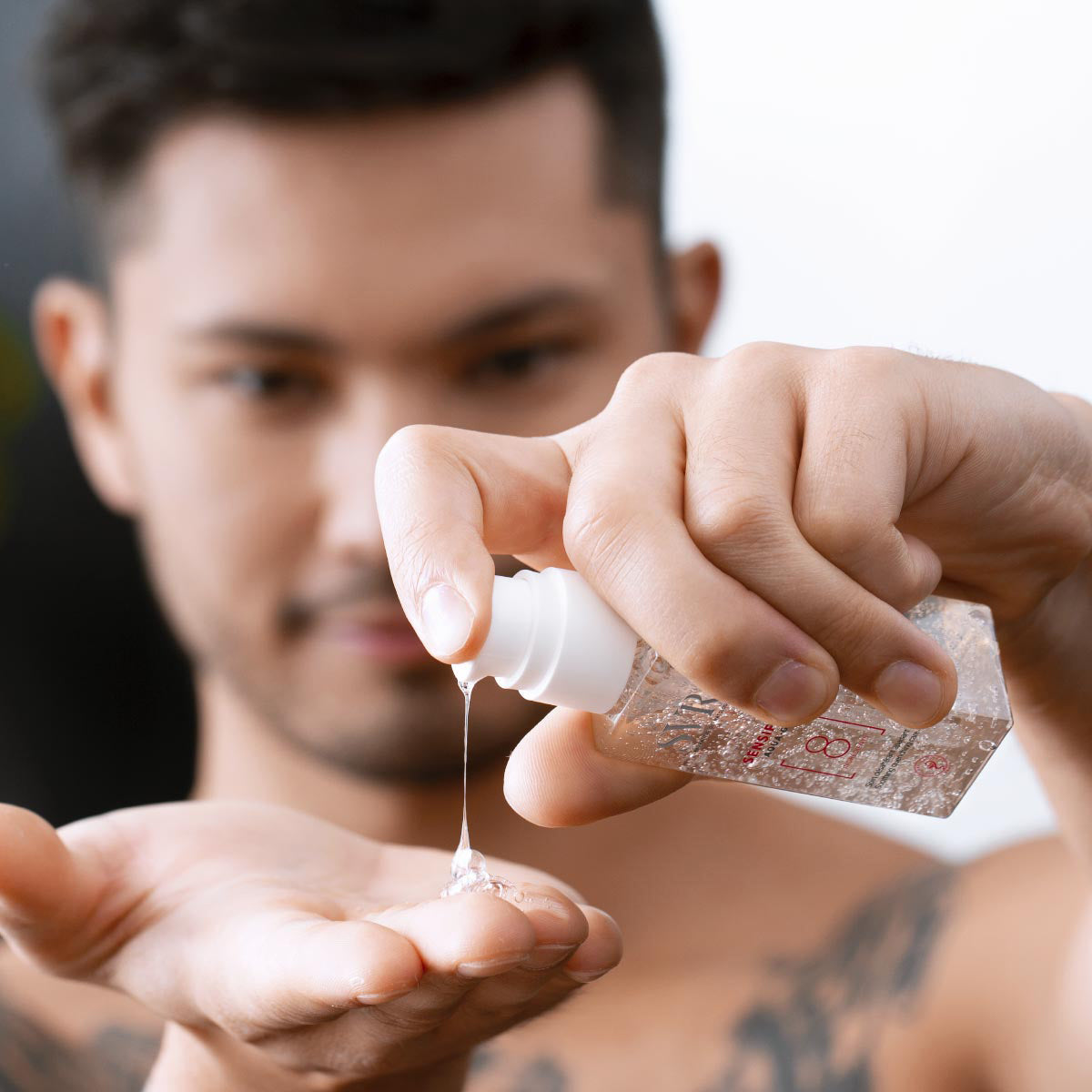 Hombre aplicando el gel hidratante transparente SVR Sensifine Aqua-Gel desde un envase dosificador sobre su mano.