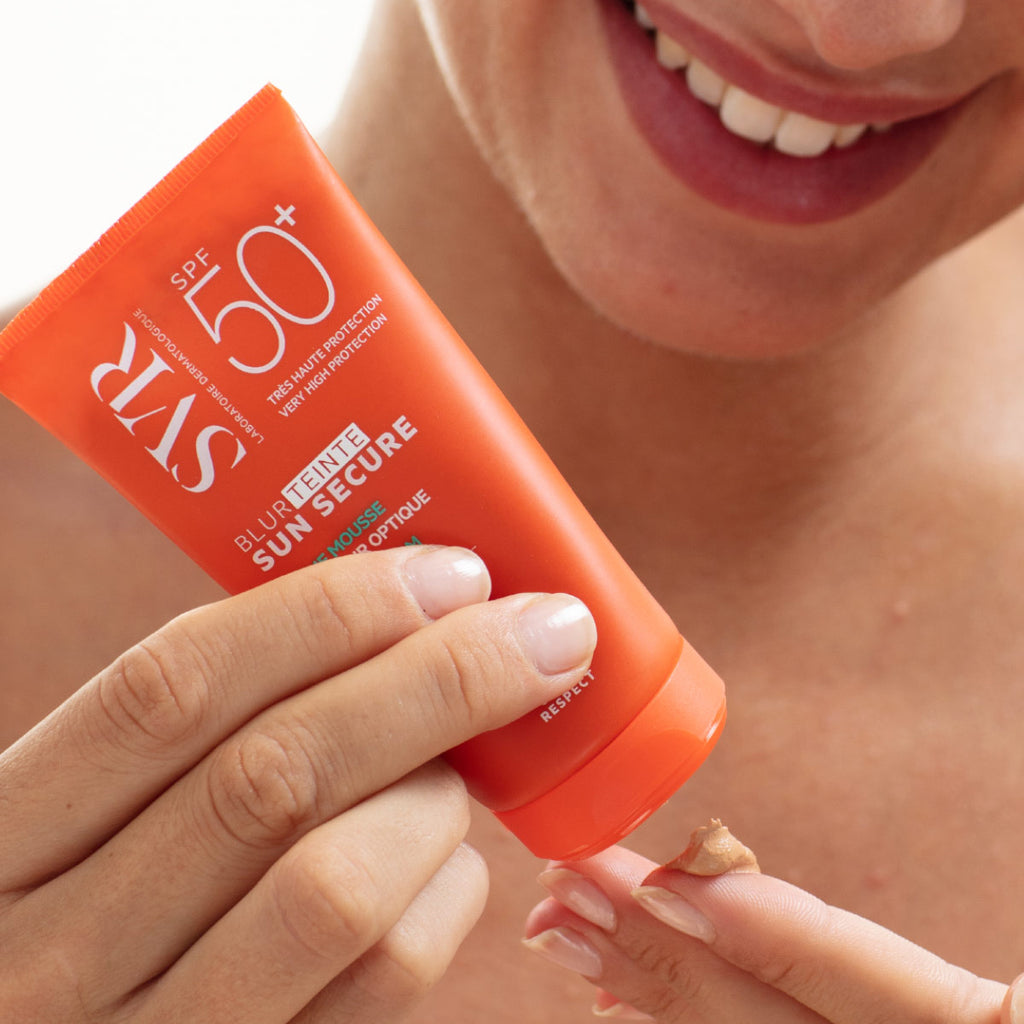 Una mujer aplicando en una de sus manos el Sunsecure Blur Teinte 50+spf de SVR