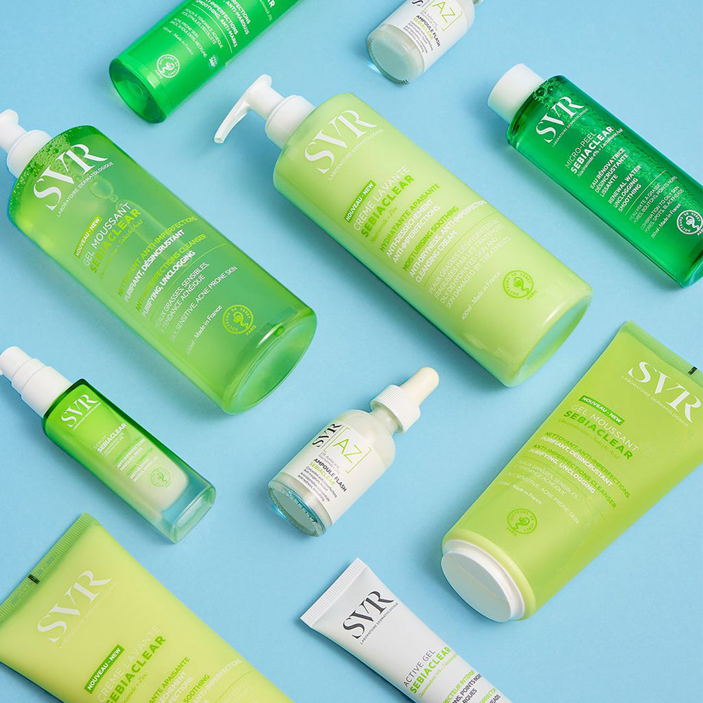 Varios productos de la gama SEBIACLEAR para pieles con imperfecciones con tendencia al acne acostados en un fondo azul