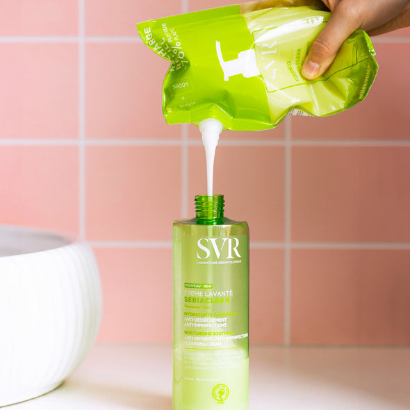 Rellenando una botella de 400 ml de la Creme Levante de SEBIACLEAR de SVR con el eco refill en un baño con fondo rosa